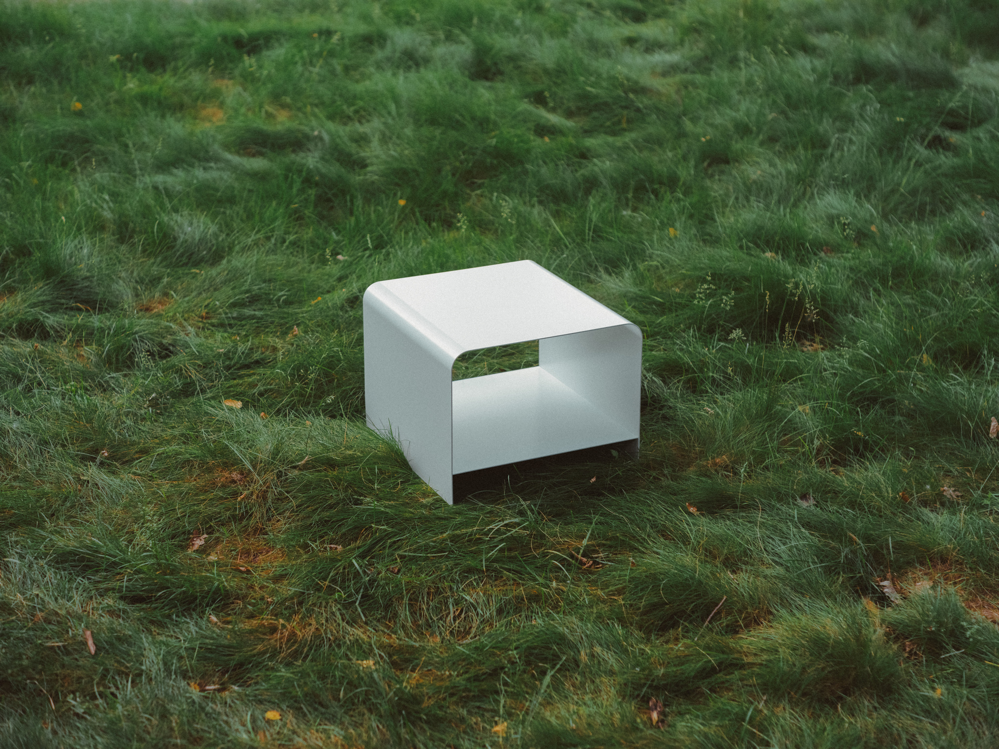 View of MEL's Radius Table in white outside amongst long grass